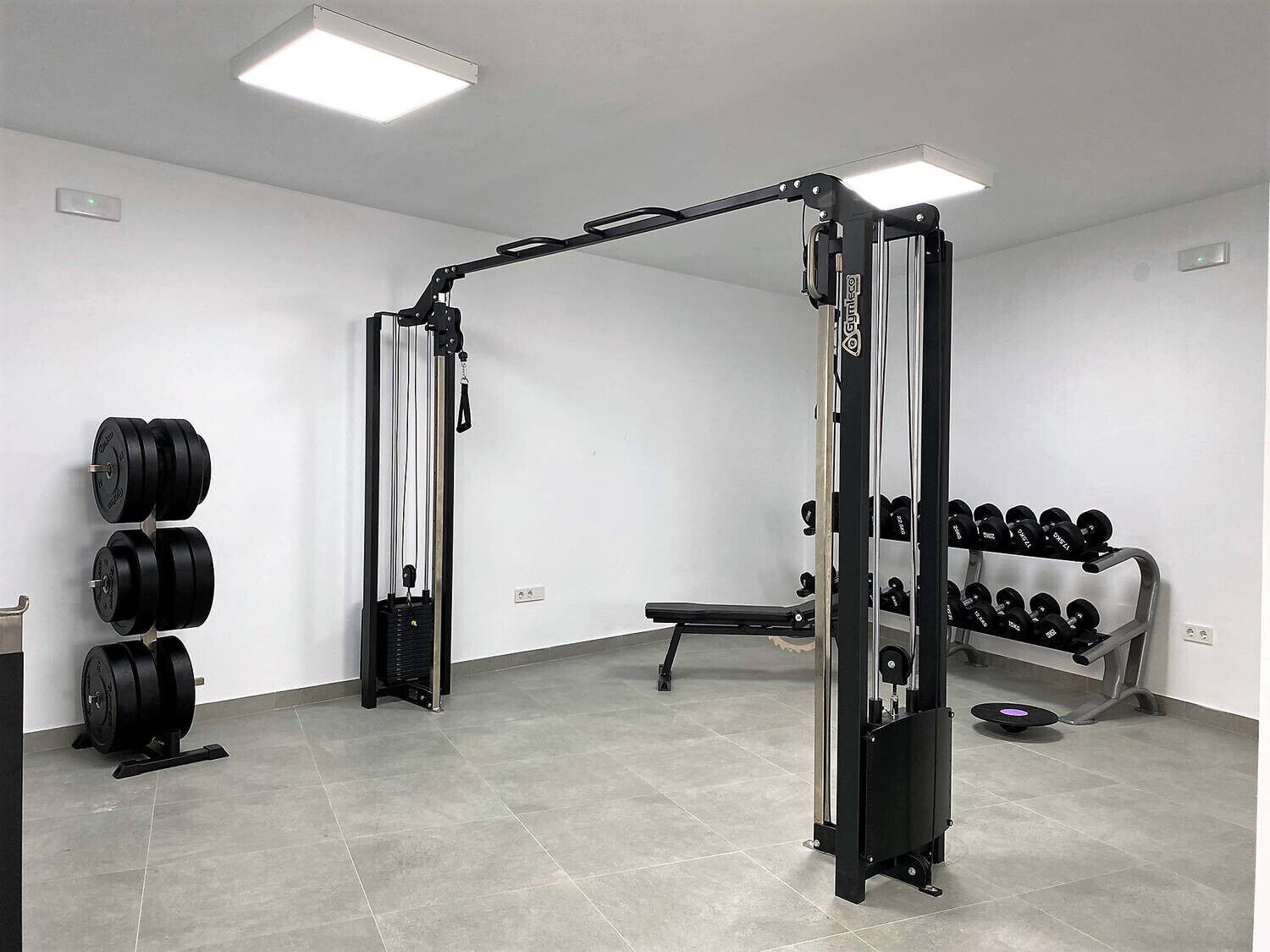 A gym with weightlifting equipment, including a squat rack and dumbbells.