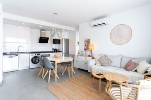 A modern apartment with a kitchen, dining area, and living room. - Balcon del Mar Seaview 211 by Casasol (Nerja)