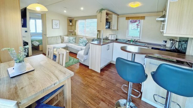 Een compacte keuken met een eethoek, een zithoekje en een kitchenette.