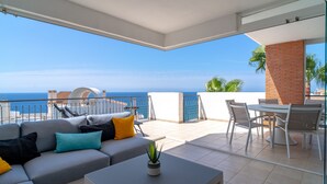 A balcony with a sofa, table, and chairs, overlooking the sea. - Calaceite 5101 Ocean Paradise by Casasol (Torrox)