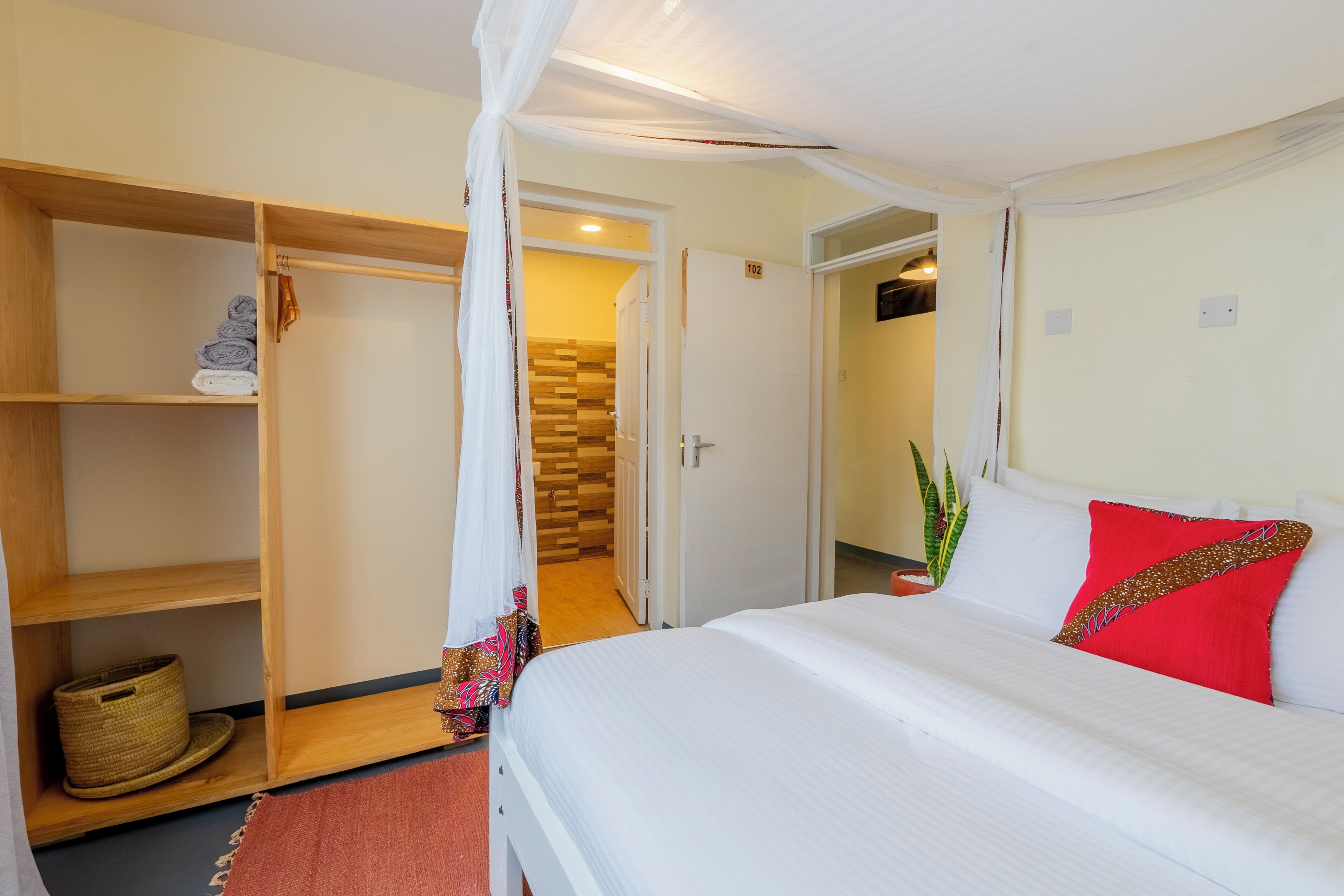 A bedroom with a bed, a wardrobe, and a bathroom door.