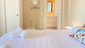 A hotel room with a bed, a chair, a wardrobe, a bathroom with a mirror, and a bedside table. - Senorio de Capistrano by Casasol (Nerja)