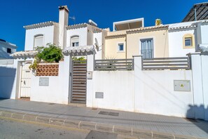 A white building with a gated entrance, a satellite dish, and a small window. - Villa Andalucía Esplendor by Casasol (Nerja)