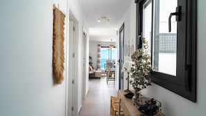 A hallway with a dining area, a plant, and a window with blinds. - Terrazas de Ladera A2 Luxury by Casasol (Nerja)
