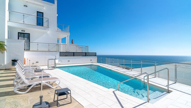 A modern pool area with clear blue water, sun loungers, and a view of the ocean. - Terrazas de Ladera A2 Luxury by Casasol (Nerja)