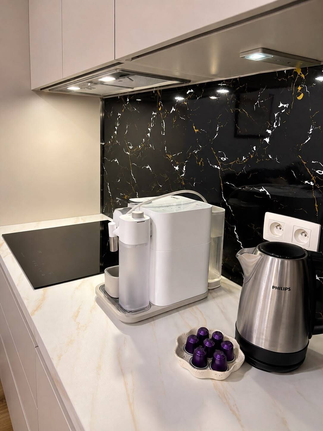 Una cocina moderna con cafetera integrada, hervidor y un plato de huevos morados.