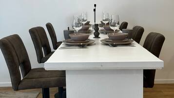Ein Esszimmer mit Tisch, Geschirr, Gläsern und Stühlen.