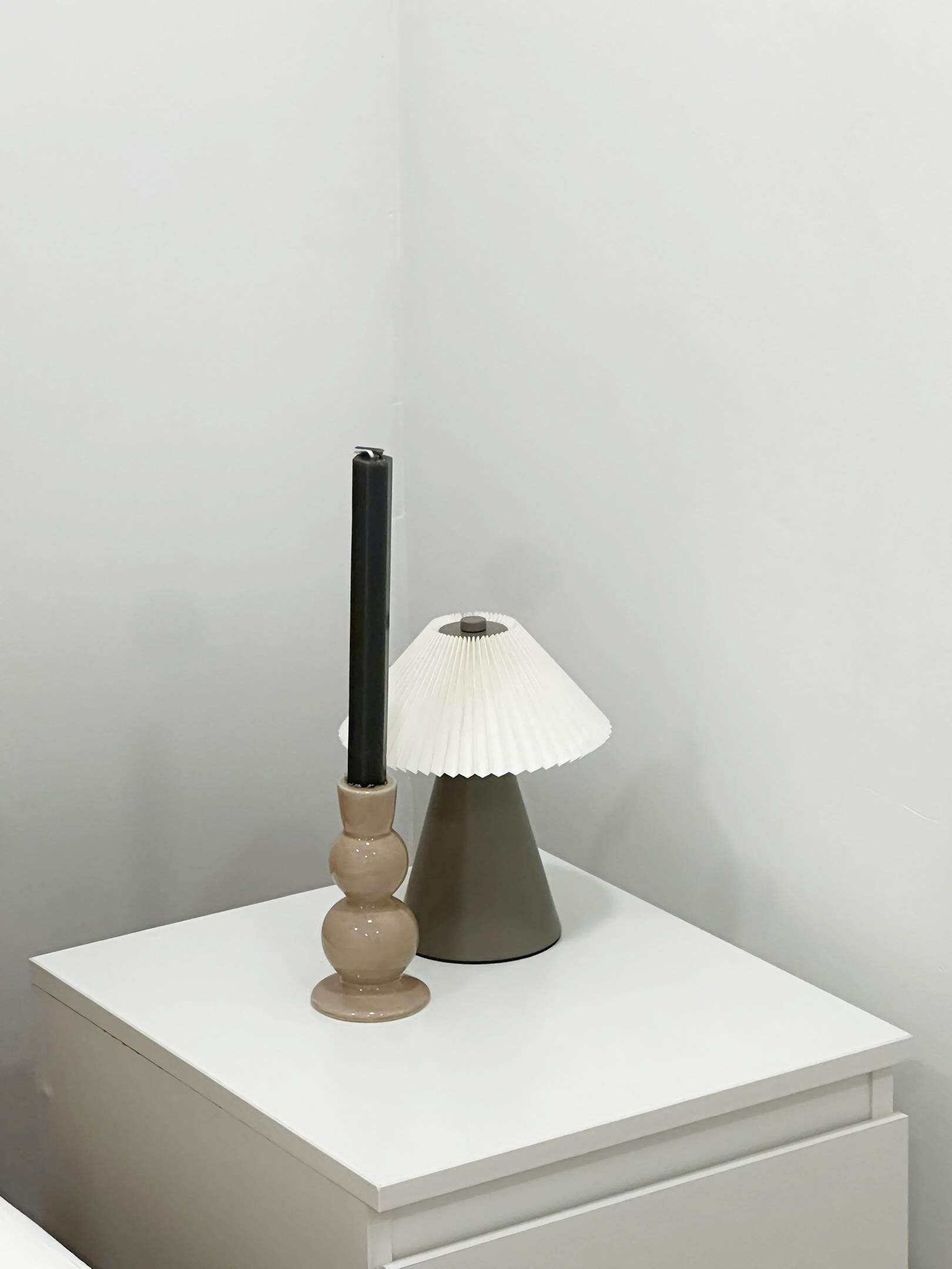 A bedside table with a lamp and a candle.