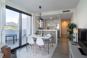 Eine moderne Wohnung mit Essbereich, Küche und Balkon.