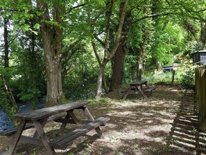 A picnic area with wooden benches and a dirt path. - 1 bedroom accommodation in Wadebridge (Wadebridge)