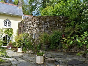 A stone wall, a yellow building, and a stone pathway. - 1 bedroom accommodation in Wadebridge (Wadebridge)