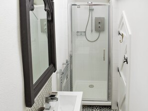 A bathroom with a shower, a sink, and a mirror. - 1 bedroom accommodation in Wadebridge (Wadebridge)