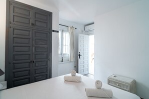 A hotel room with a large bed, a wardrobe, and a small wicker basket. - Casablanca Sunny Terrace by Casasol (Nerja)