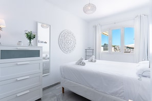 A modern bedroom with a bed, a dresser, a mirror, and a view of the outside. - Verano Azul Seasun 90B by Casasol (Nerja)