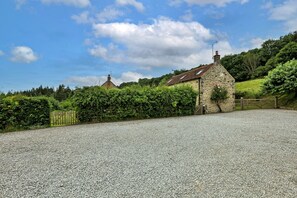 A stone building with a gravel driveway and a wooden gate. - The Burrows (Wass)