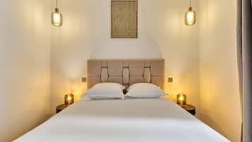Een bed met hoofdeinde, twee bedlampen en een kunstwerk aan de muur.