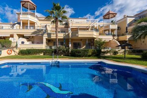 A hotel with a swimming pool, multiple balconies, and palm trees. - Jardines de Burriana Deluxe by Casasol (Nerja)