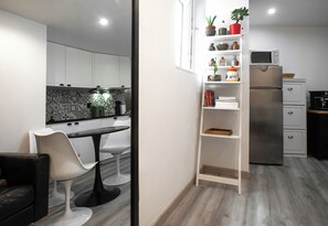 A modern kitchen with white cabinetry, a built-in microwave, and a stainless steel refrigerator. - Casa Catarina Stylish Stay In Lisbons Heart (Lisboa)