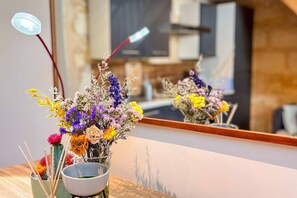 A room with a mirror reflecting a floral arrangement and a small table with a bowl and incense sticks. - Apartment with a Mezzanine Bedroom Bordeaux (Bordeaux)