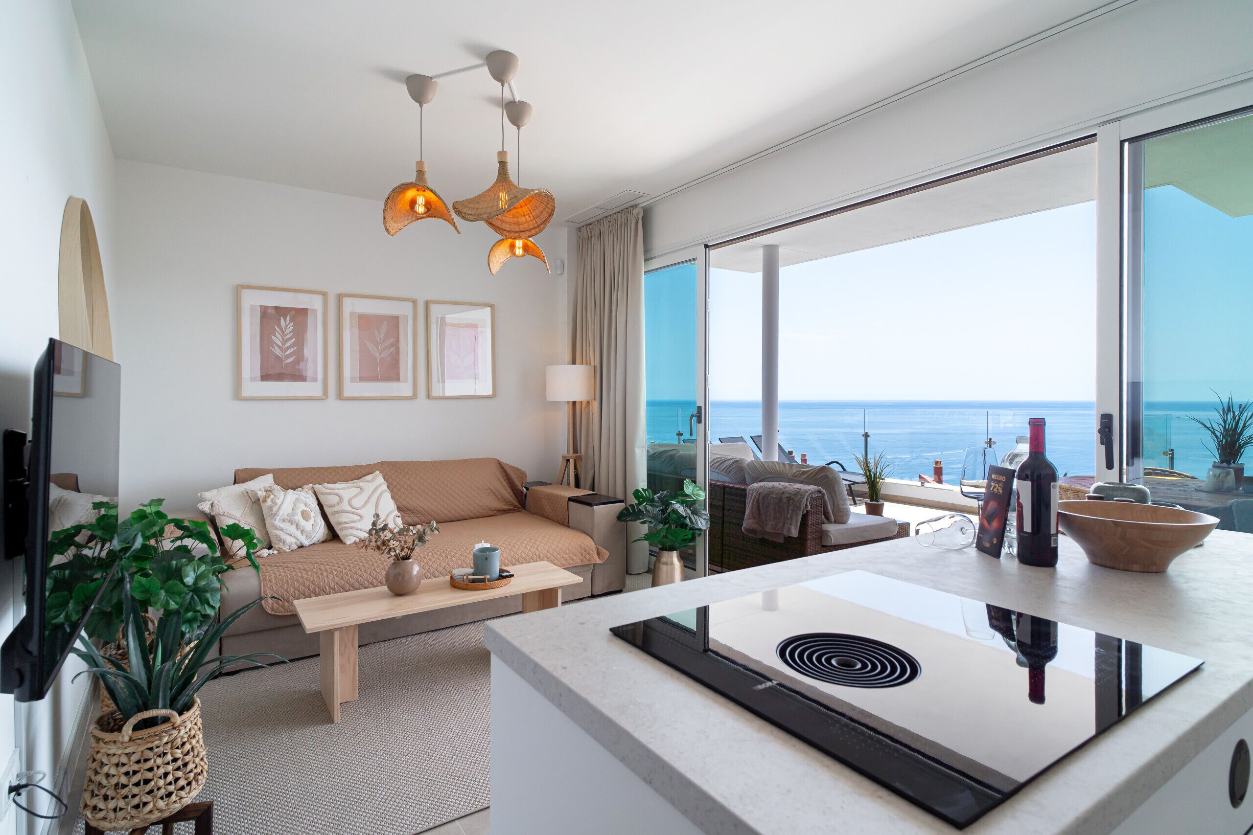 A modern living room with a sofa, coffee table, and a view of the ocean.