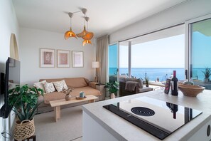 Ein modernes Wohnzimmer mit einer Couch, einem Couchtisch und Meerblick.
