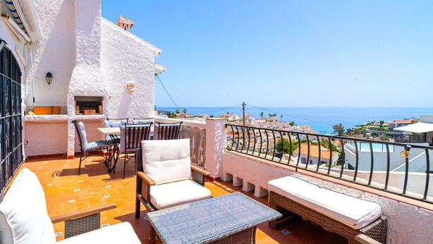 A terrace with white walls, a table, chairs, and a sofa. - Casa Rosa Splash Pool by Casasol (Nerja)