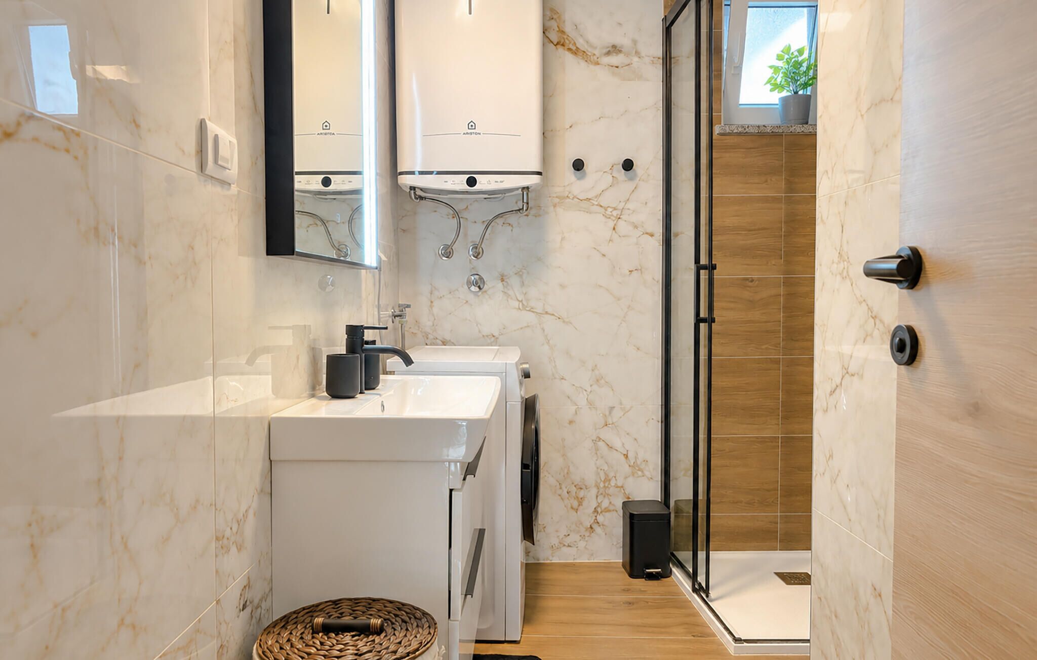 Een moderne badkamer met een wit wastafel, een spiegel, een douche en een houten vloer.