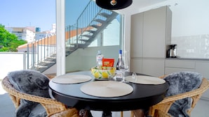 A dining area with a round table, two wicker chairs, a bowl of lemons, a bottle of water, and a coffee maker. - Casa Solera by Casasol (Nerja)
