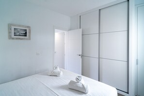 A minimalist bedroom with a single bed, a framed picture on the wall, and a sliding wardrobe. - Toboso 1R Beach Living (Nerja)