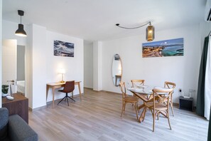 A modern living room with a dining area, wooden flooring, and artwork on the walls. - Toboso 1R Beach Living (Nerja)