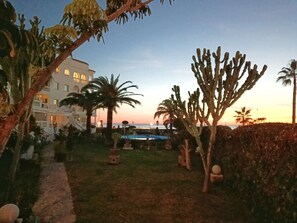 A resort with a pool, palm trees, and a building with arched windows. - Stella Maris Suite by Casasol (Nerja)