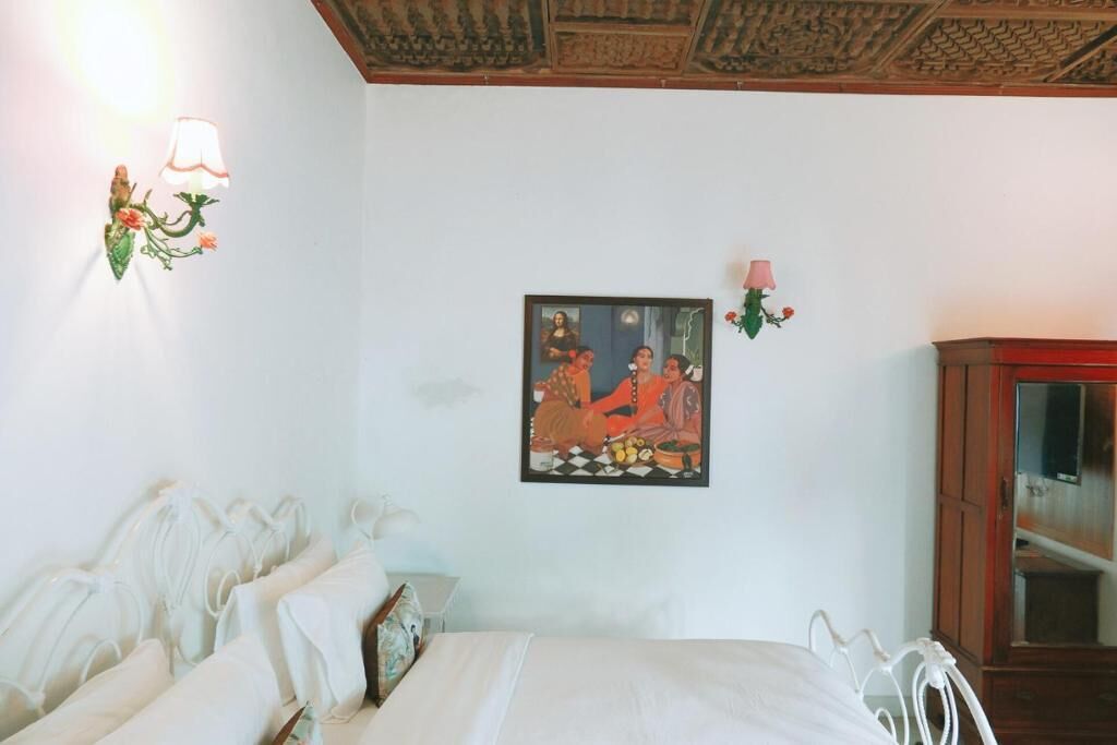 Un dormitorio con cama, una lámpara de pared, un cuadro enmarcado y un armario.