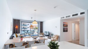 Un salon moderne avec un coin repas, de grandes fenêtres et une vue sur la ville.