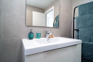 A bathroom with a white sink, a mirror, and a towel rack with a towel. - Duna Beach Torrox Costa by Casasol (Torrox)