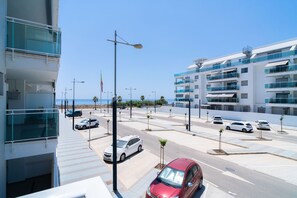 A modern building with balconies, a parking area, and a clear view of the sea. - Duna Beach Torrox Costa by Casasol (Torrox)