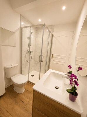 Een douche, handdoeken, zeep, toiletpapier