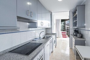 Eine moderne Küche mit Edelstahlgeräten, einem eingebauten Ofen und einer Arbeitsplatte aus Granit.