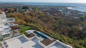 Uma área residencial com piscina, vista para o mar e paisagem montanhosa.