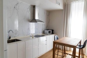 Eine moderne Küche mit weißen Schränken, einer eingebauten Mikrowelle und einem Holzespeisesatz.