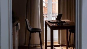 Een kamer met een bureau, stoel en laptop.