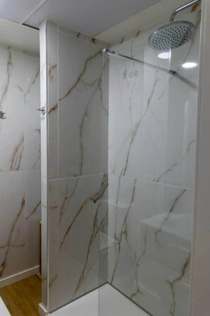 A glass-enclosed shower with marble walls. - Suite-Studio 2 Apartment at Teatro24 (Alicante)
