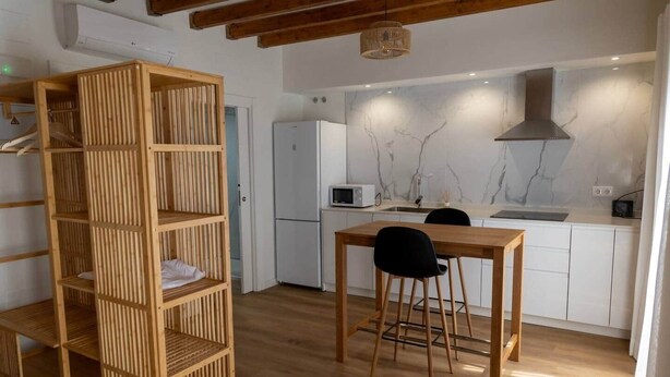 Een moderne keuken met witte kastjes, een ingebouwde magnetron en een roestvrijstalen afzuigkap.