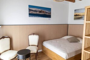 A room with a bed, a chair, a small table, and two wall-mounted pictures. - Suite-Studio 6 Apartment at Teatro24 (Alicante)