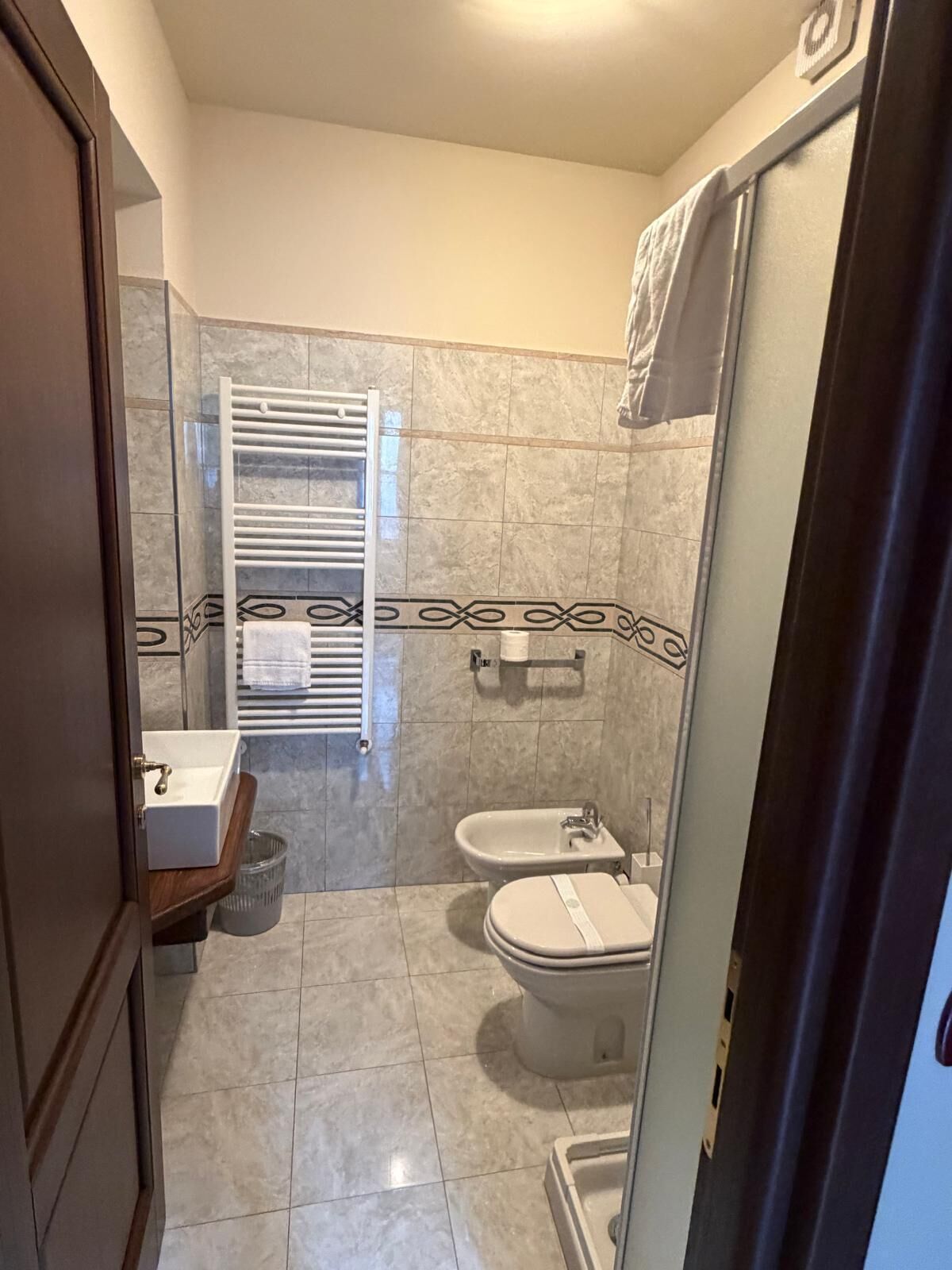 A bathroom with a toilet, bidet, and a towel rack.