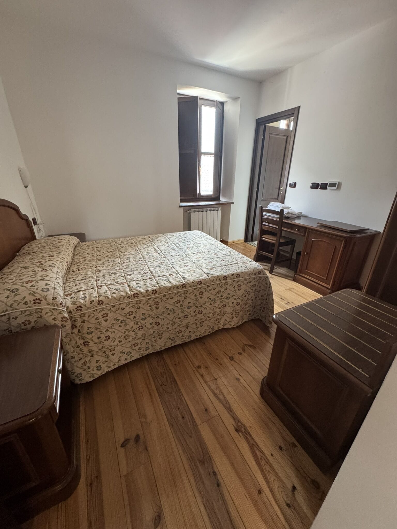 Ein Schlafzimmer mit einem Bett, einem Schreibtisch und einem Stuhl.