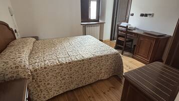 Ein Schlafzimmer mit einem Bett, einem Schreibtisch und einem Stuhl.