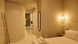 A hotel room with a bed, a bedside lamp, a mirror, a ladder, and a view into another room. - Arrels Mercat (Valencia)