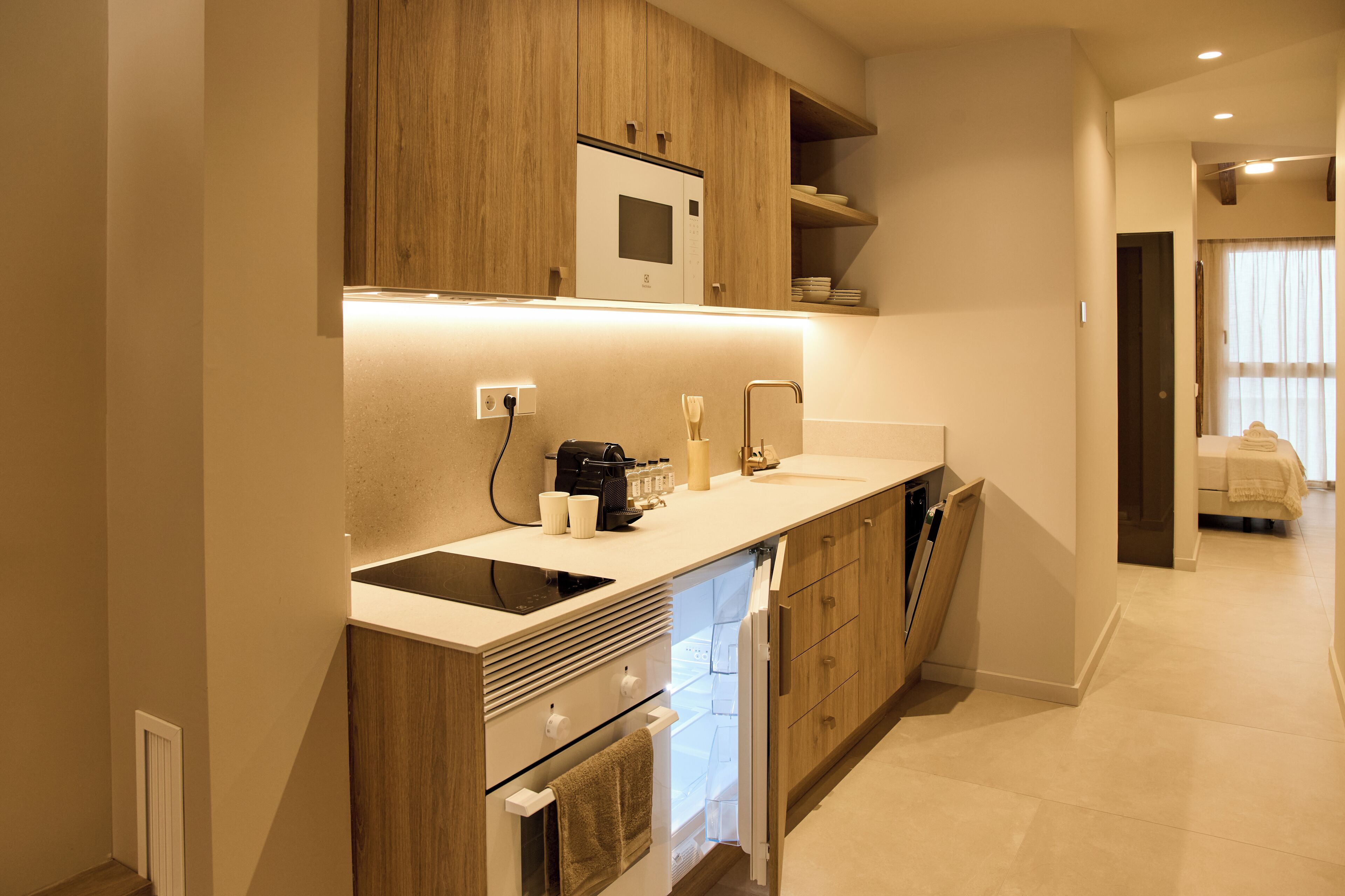 A modern kitchen with wooden cabinets, a built-in microwave, and a dishwasher.