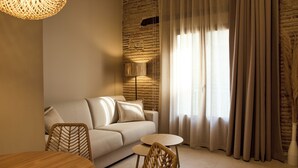 A modern living room with a sofa, a round table, and a chair. - Arrels Mercat (Valencia)