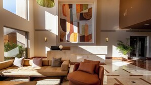 A spacious lobby with a modern sofa, a coffee table, and a large abstract painting on the wall.